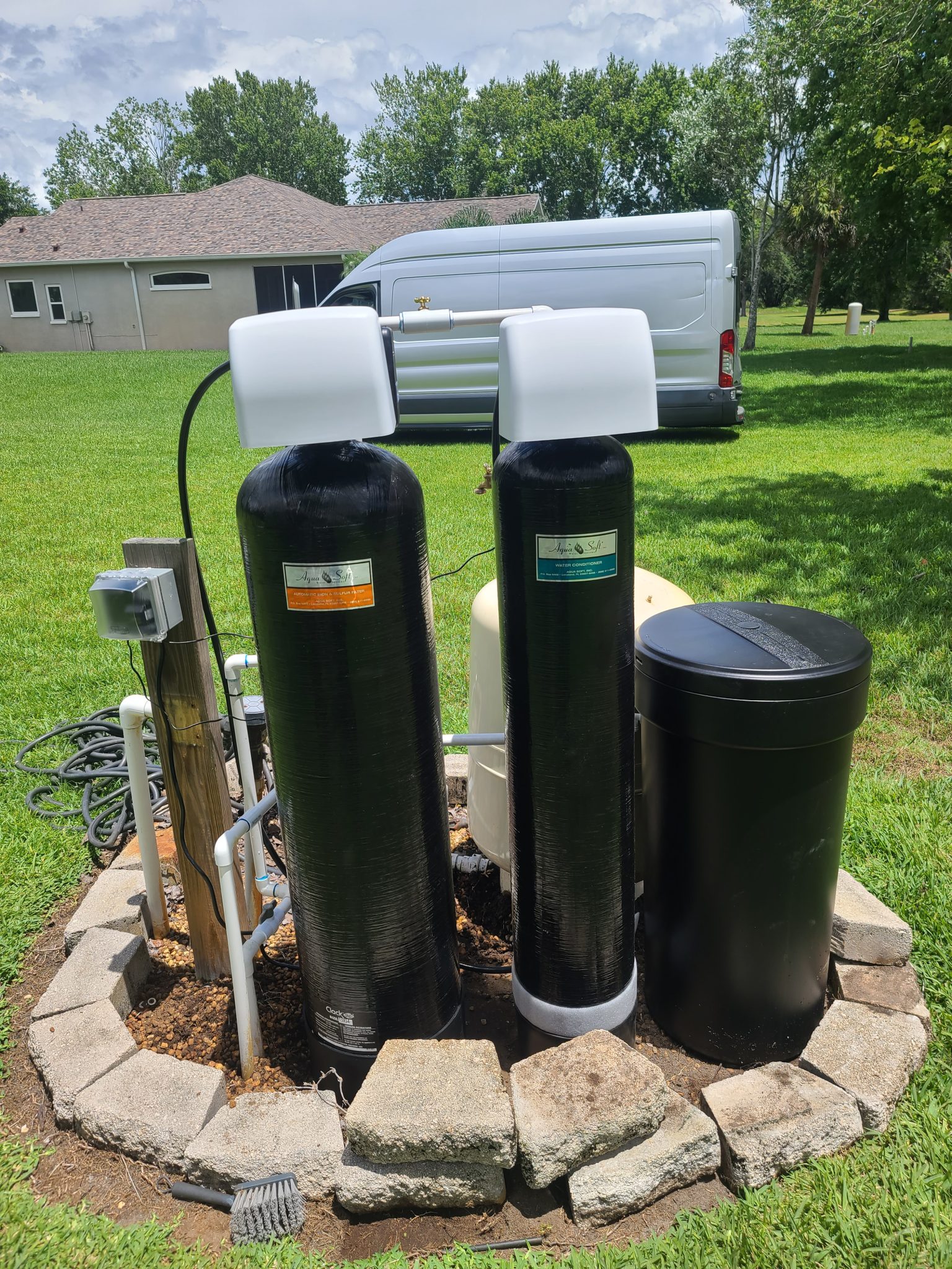 Outdoor water softener tanks near van